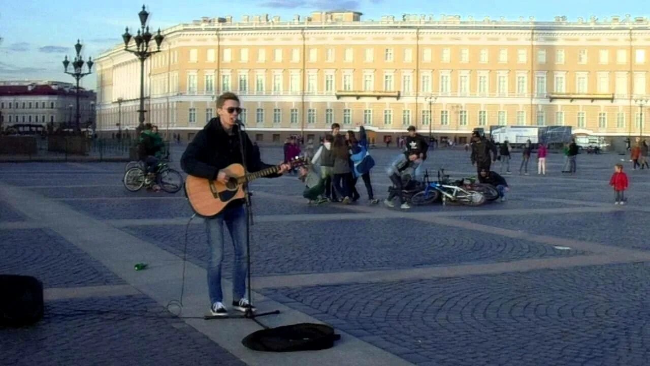 На сцене установленной прямо на площади играют. Стрыкало я бью женщин и детей. Я бью женщин и детей электрогитара.