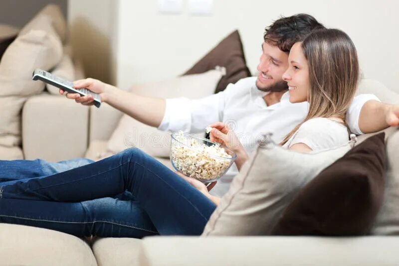 Young Happy Couple on Couch at Home Enjoying Using Digital Tablet Stock Image - 