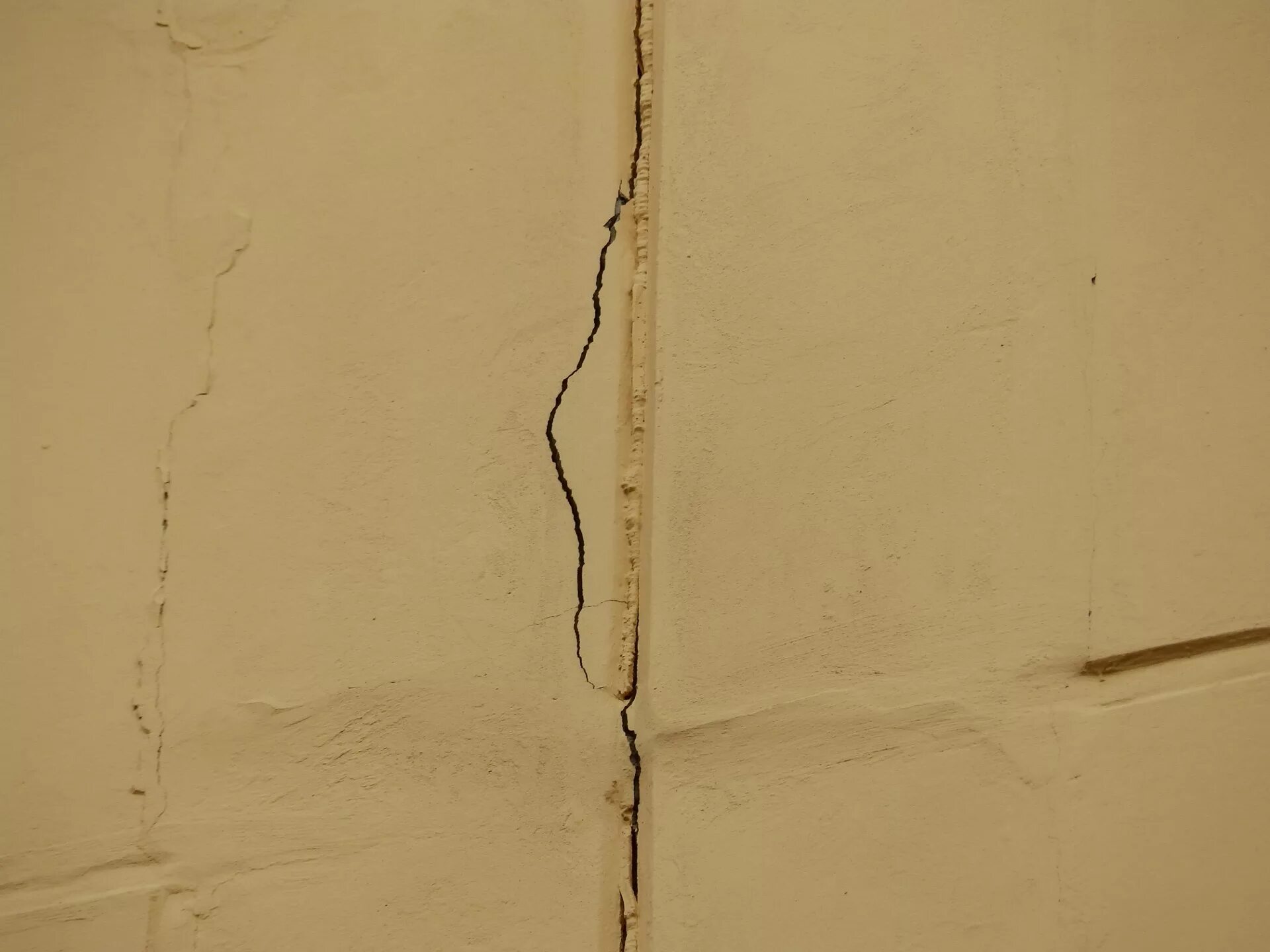 Усадочные трещины в штукатурном слое. Трещина на штукатурке на стене. Трещины в перегородках. Сквозная трещина в стене.