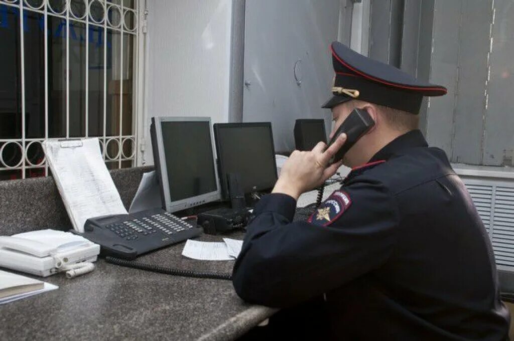 Анонимно позвонить в полицию. Полицейский с телефоном. Полицейский за телефоном. Звонок в полицию. Полицейский дежурной части с телефоном.