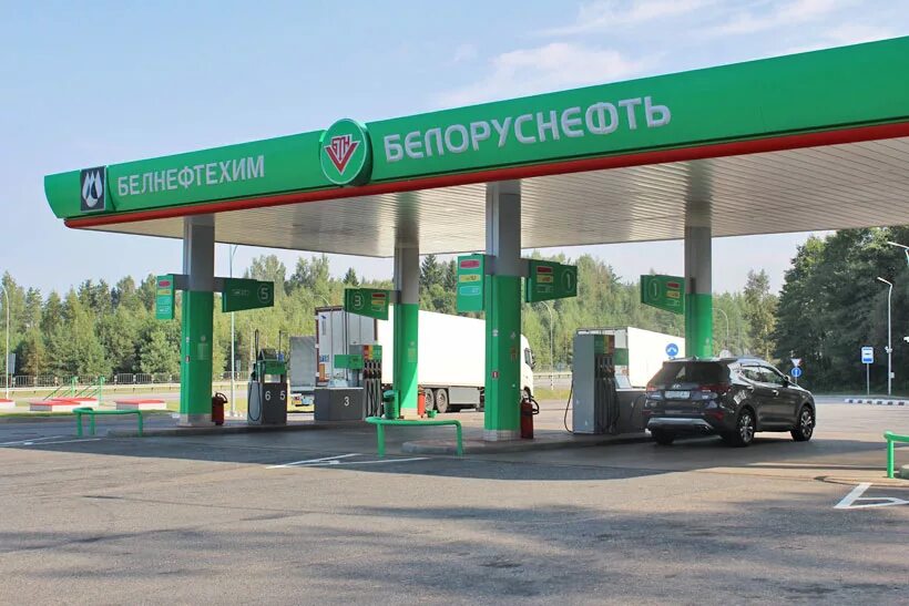 Цена 95 бензина в беларуси. Заправка фото с зелёным газоном.