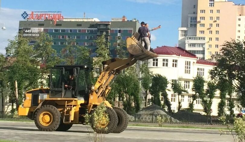 Тракторная екатеринбург. Человек в ковше погрузчика. Трактор с ковшом рабочий. Ковш. Люди в ковше трактора.