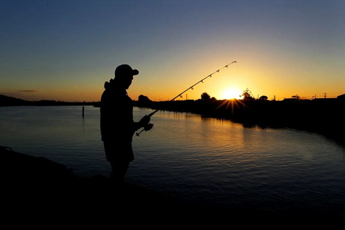 Озеро с удочкой. Рыбак с удочкой. Рыбак ловит. Рыбак на берегу. Красивая рыбалка.
