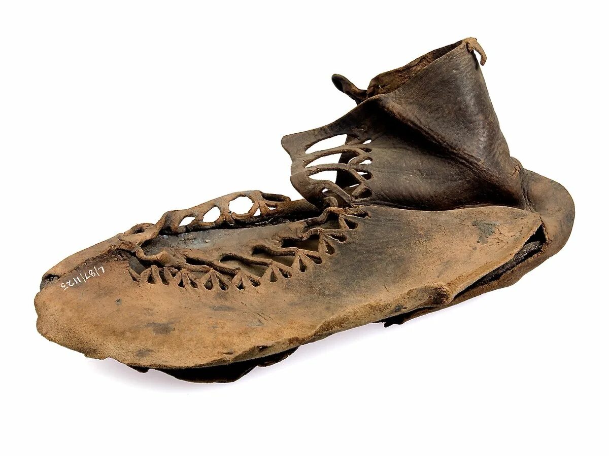 Древняя кожаная обувь. Первые ботинки. Пулены обувь 14 век. Сандали древнего египта. Первобытная обувь.