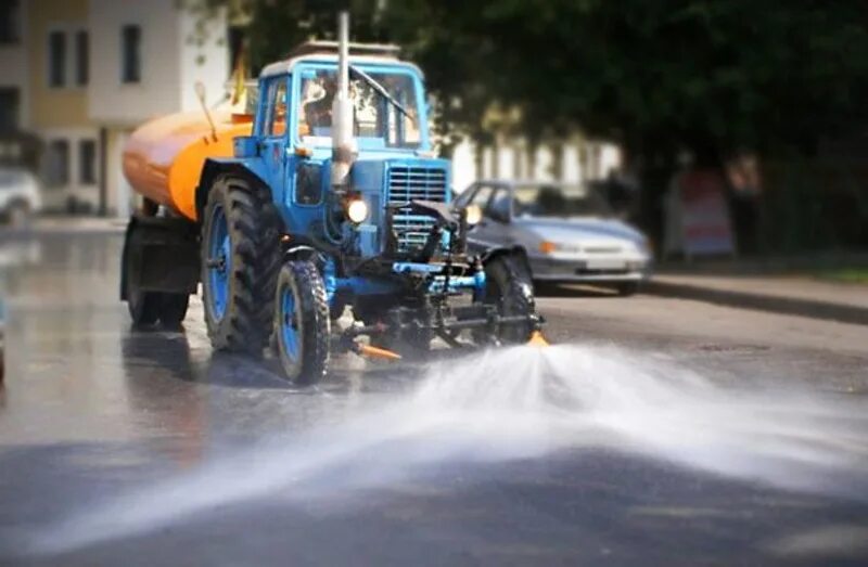 Почему моют дороги. Трактор поливает улицы. Трактор в воде. Трактор для мойки улиц. Мытьё дорог МТЗ-.