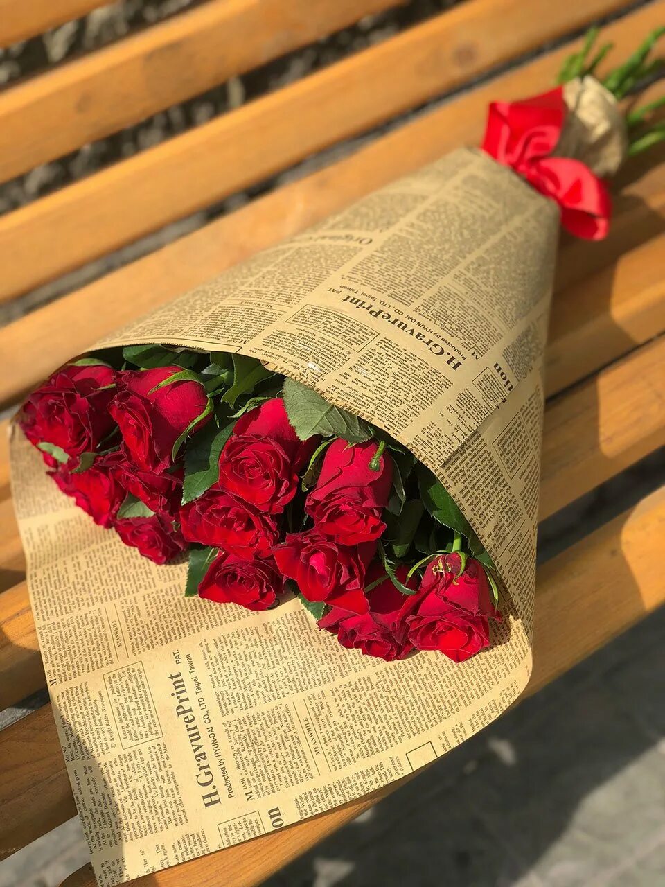 Во что упаковывают цветы. Букет красных роз в крафтовой бумаге. Бумага для букетов. Букет в газетной бумаге. Букет цветов в обертке.