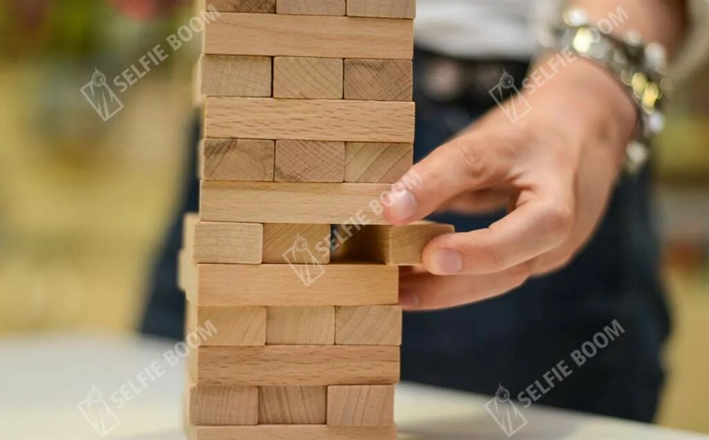 Деревянная игра строим башню. Jenga игра. падающая башня дженга. дженга 1970. дженга пирамида.
