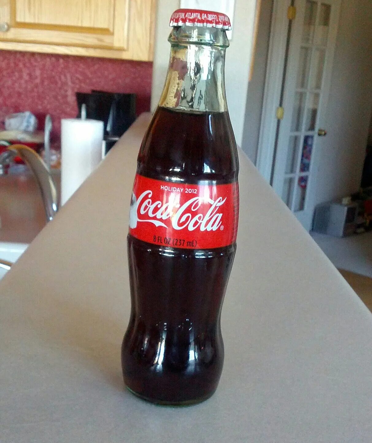Кола бутылка на столе. Coca cola грузинская. грузинская кока кола в стекле. большая стеклянная бутылка колы. бутылка стеклянная кока кола в руке.