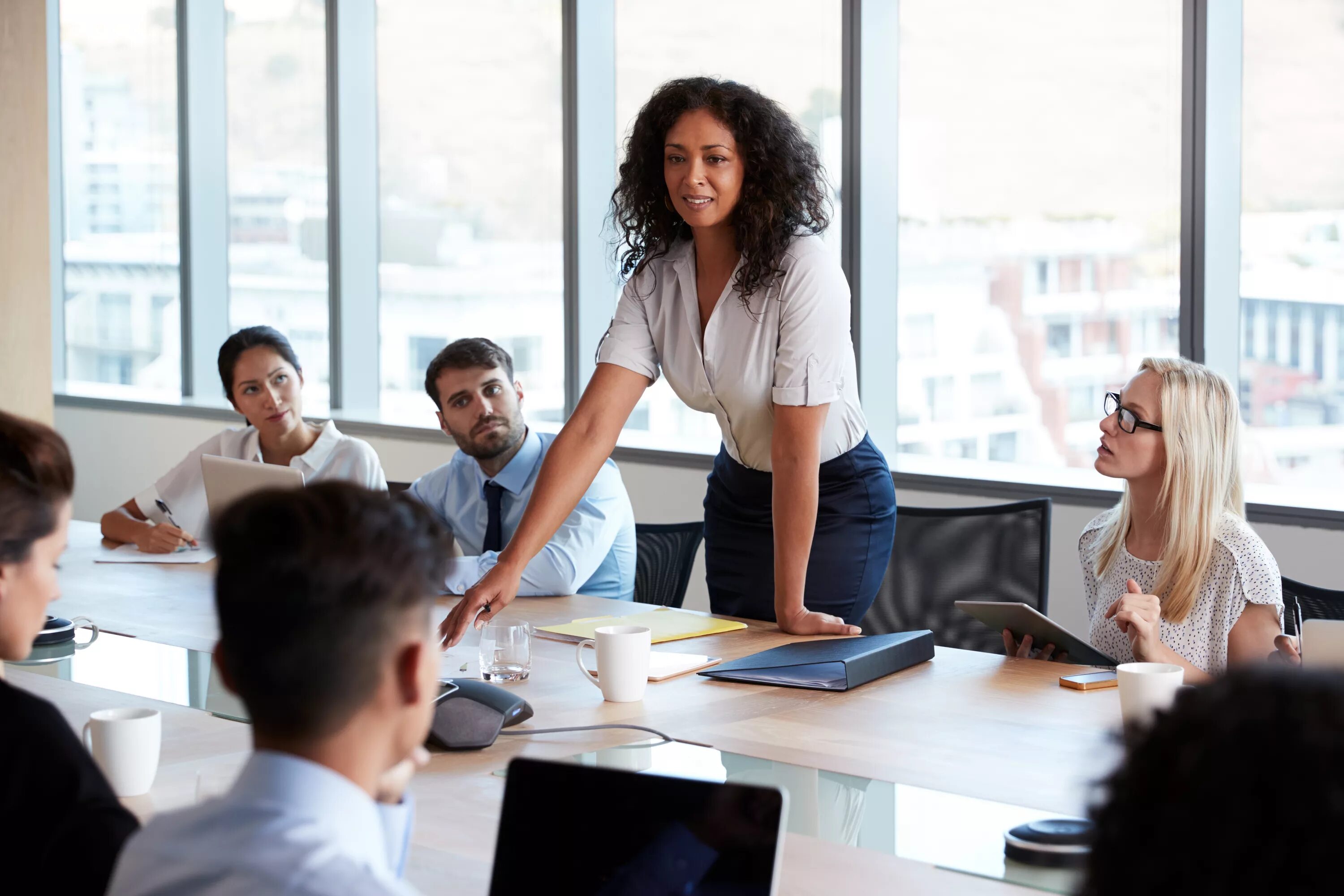 Holding a meeting. Люди в офисе. Люди за столом в офисе. Тренинг менеджер. Совещание в офисе.