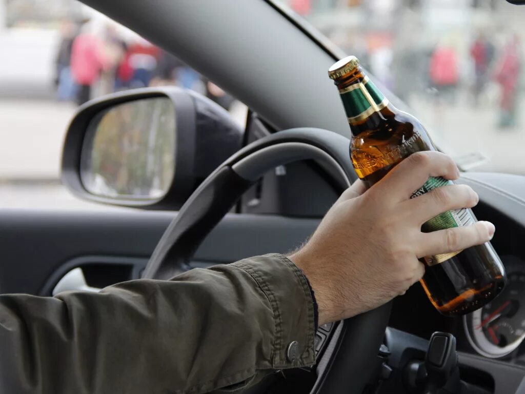 Водитель пьет за рулем. Алкоголь и автомобиль.