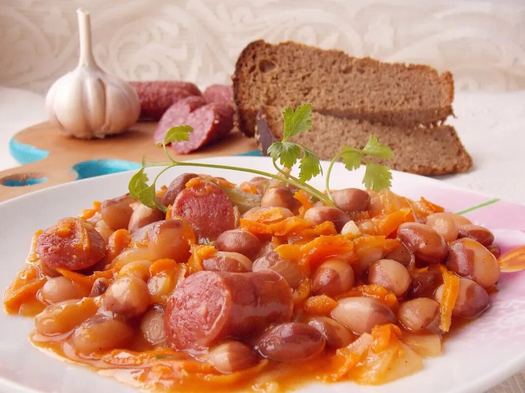 Картошка с фасолью в томатном. Фасоль с колбасками. фасоль с колбасками в томатном соусе. фасоль тушеная в томатном соусе. фасоль с колбасой тушеная.