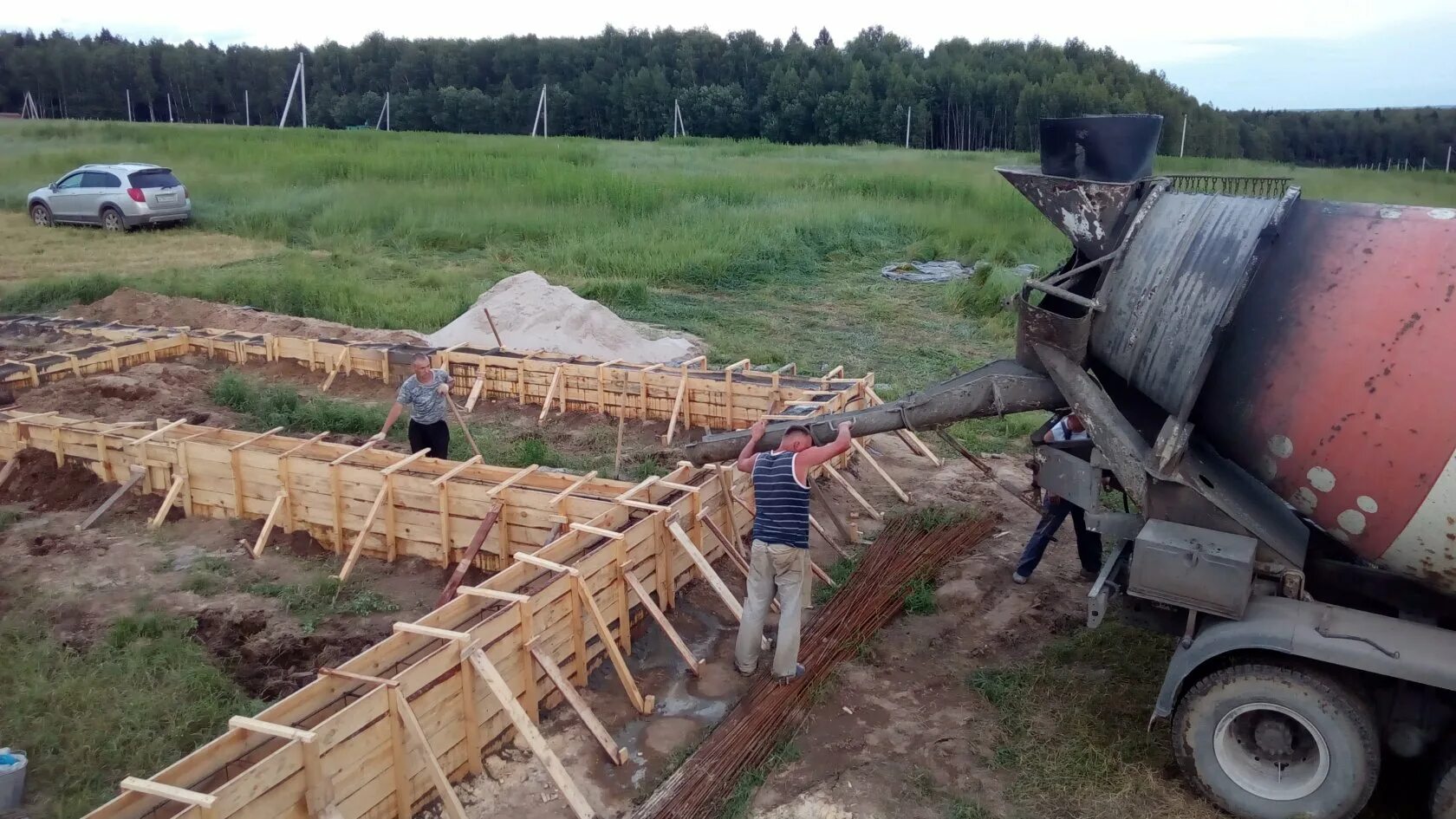 Залить фундамент миксером. Заливка фундамента. бетономешалка для фундамента. заливка фундамента бетономешалкой. желоб для заливки бетона.