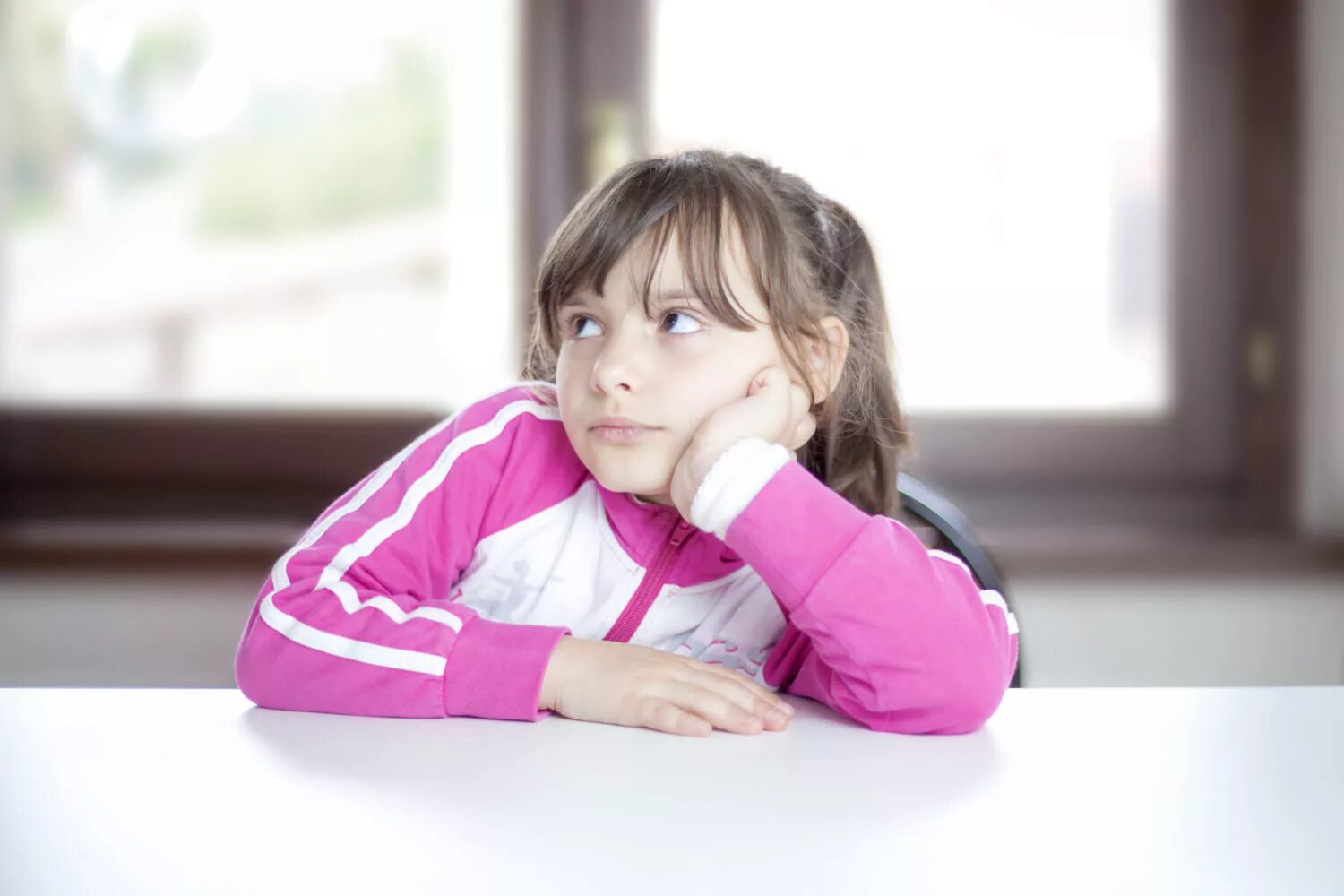 Девочка не внимательна. Первоклассник слушает учительницу. Ученик отвлекается. Девочка не внимательна. Пишущая и задумчивая девочка фото.