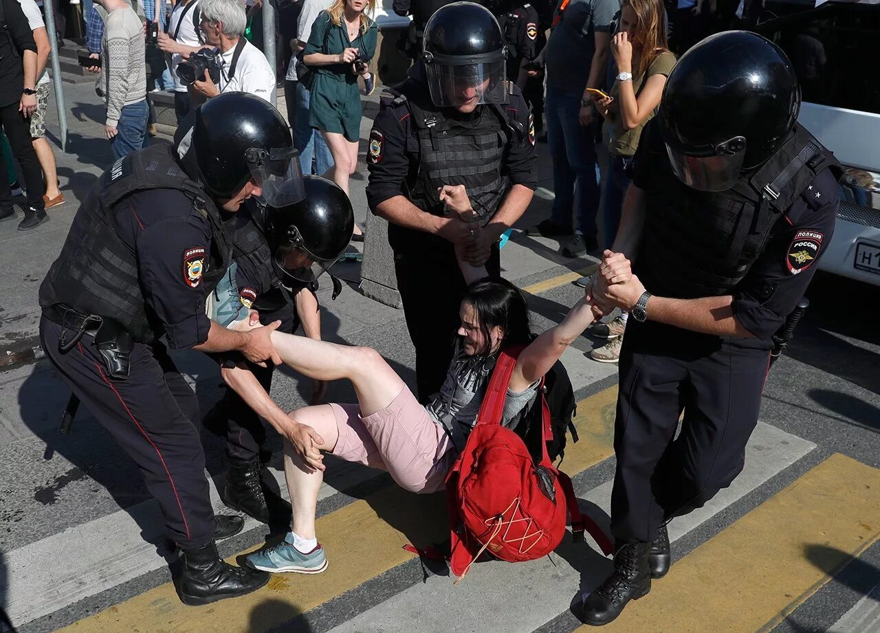 Полицейский избивает человека. Сотрудники на митинге