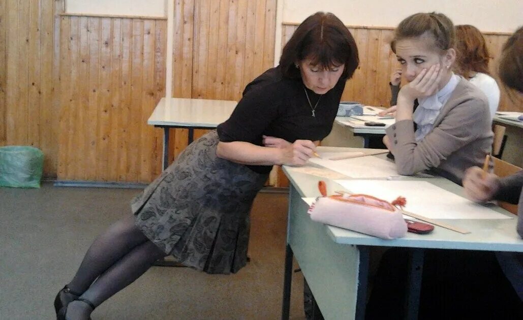 Стоит на учительницу