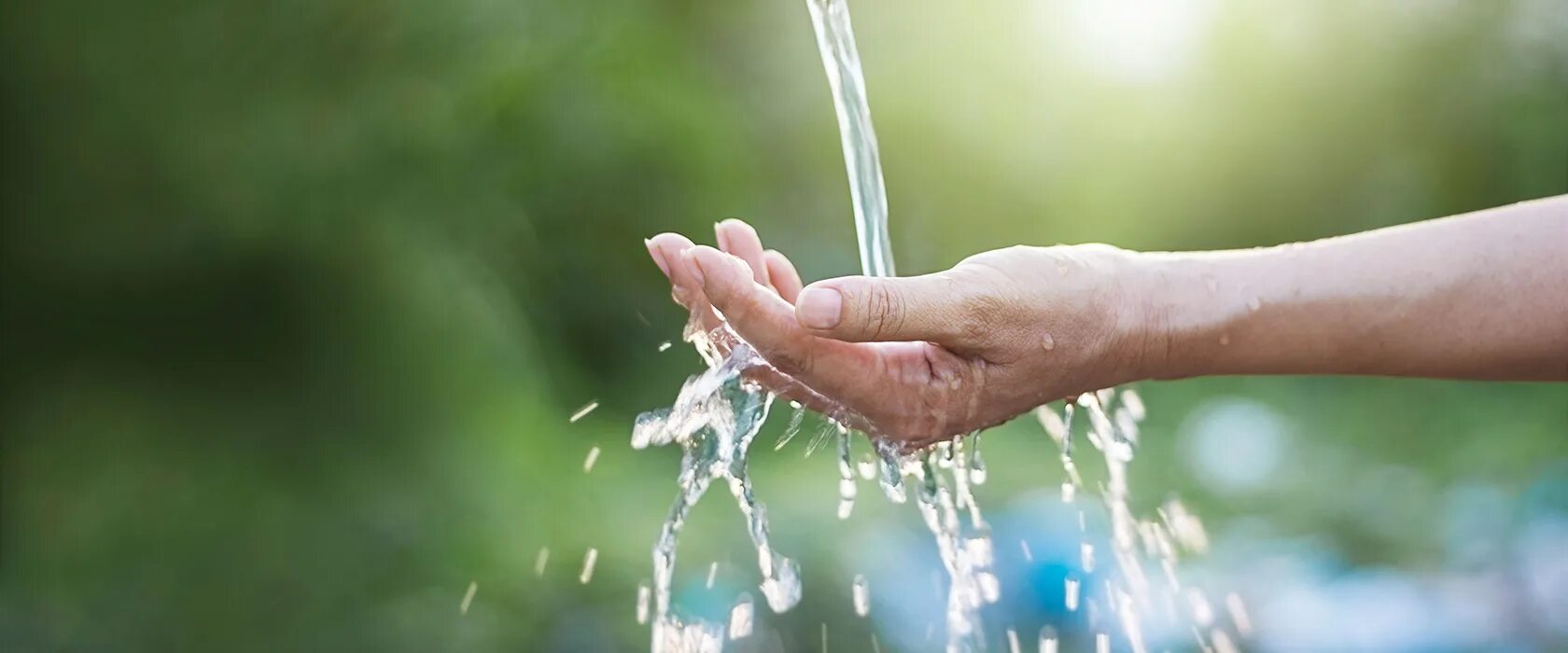 С неба льется вода. Чистая вода. Вода льется на руку. Вода в руках. Струя воды.