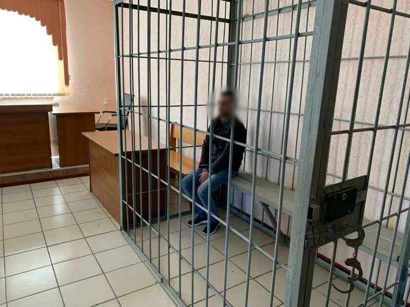 Суд признал подсудимого виновным. Клетка для осужденного в суде.