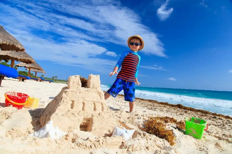 Drive a car make a sandcastle. Дети строят замок из песка. Пляж мальчик песочный замок. Мальчик на пляже строит замок. Дети строят песочный замок.