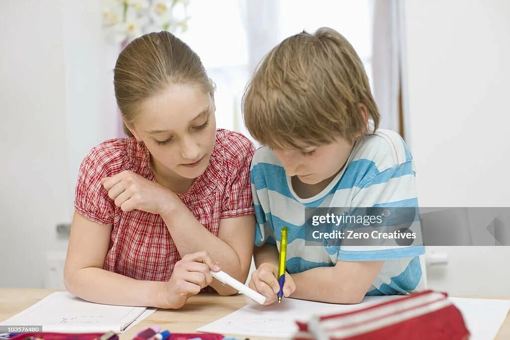 Boy and girl doing homework. Student girl doing homework pic. Looking down on a child doing homework. Helping at Home. Sister my boy