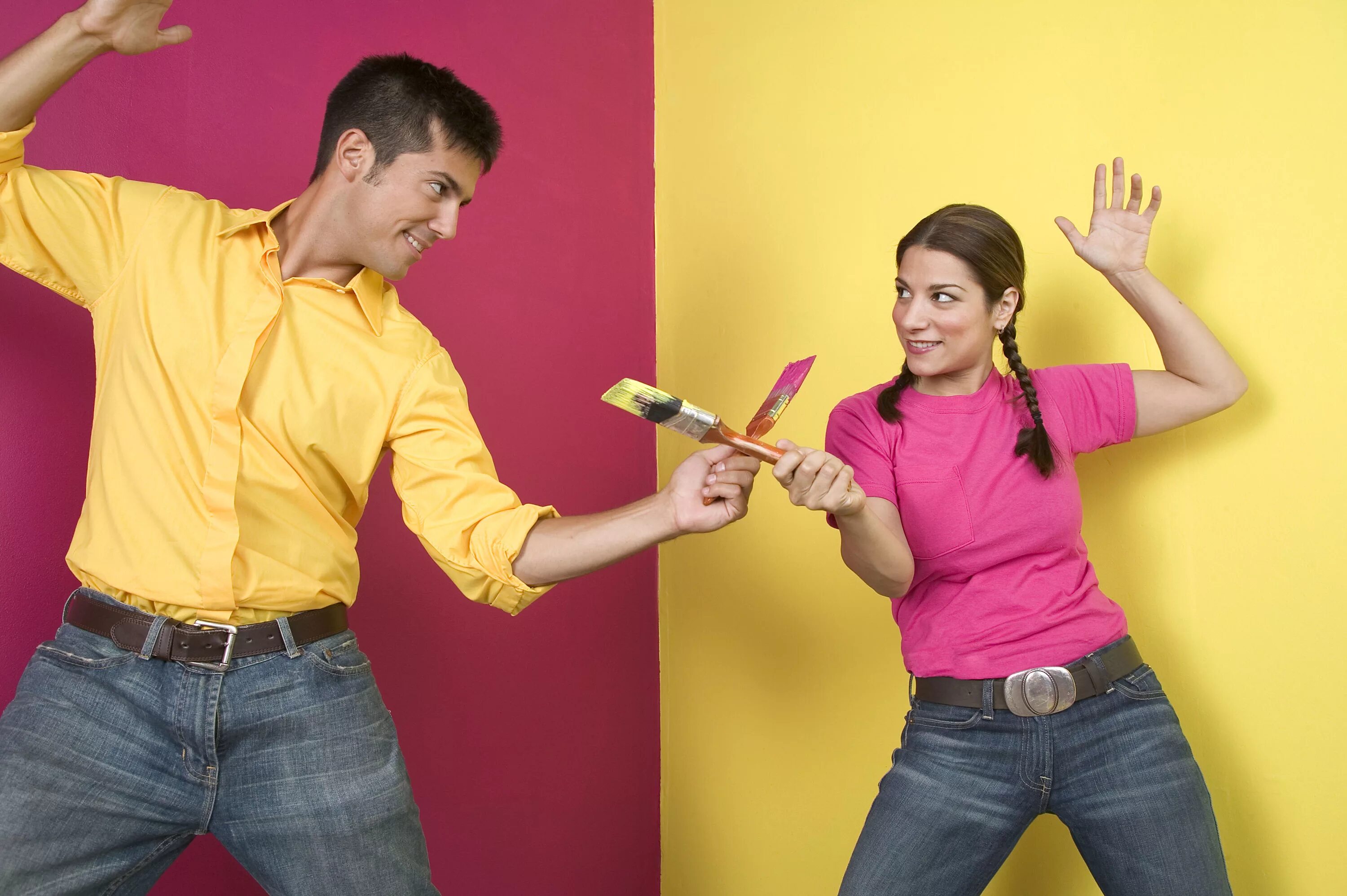 Человек клеит обои. Люди делают ремонт. Влюбленные делают ремонт. Мужчина и женщина красят стену.