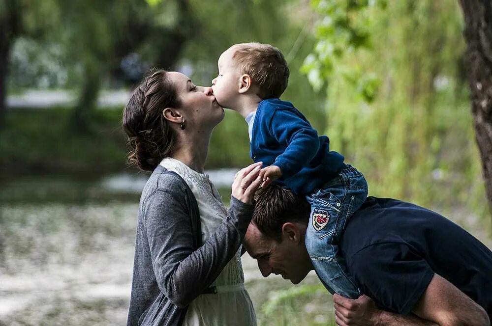 Ребенок любит взрослых. Любовь родителей к детям. Поцелуй родителей и детей. Родители целуют ребенка. Папа обнимает маму.