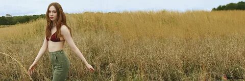 Шотландская актриса Карен Гиллан в поле в сексуальном бордовом топе и зеленых дж