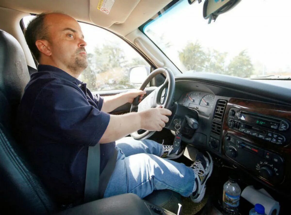 Водитель улыбается. Карлик за рулём автомобиля. Аккуратный водитель. Мотиватор для водителей. Водитель и автомобиль.