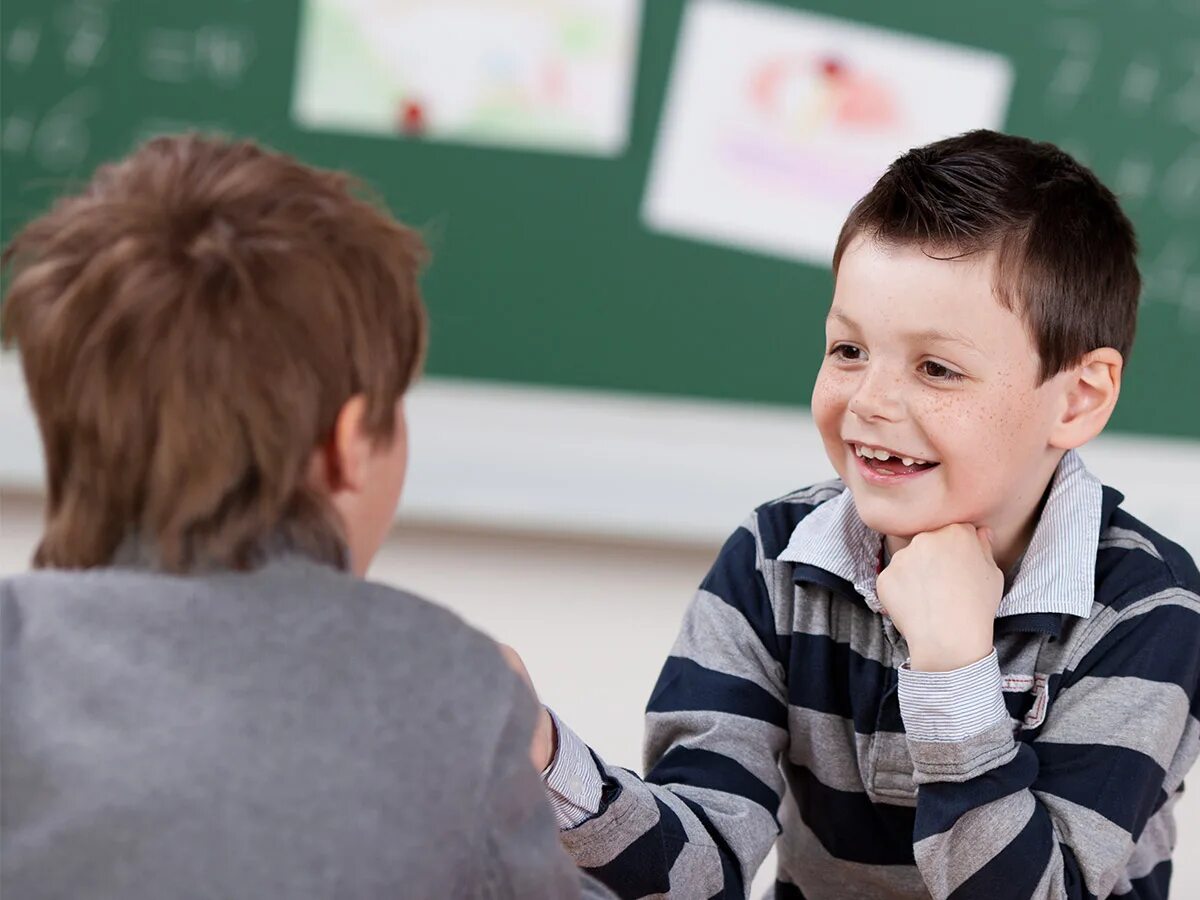 Talking at the lessons. 2 kids talking. talk in class. boy school students are talking. boy and girl talking.