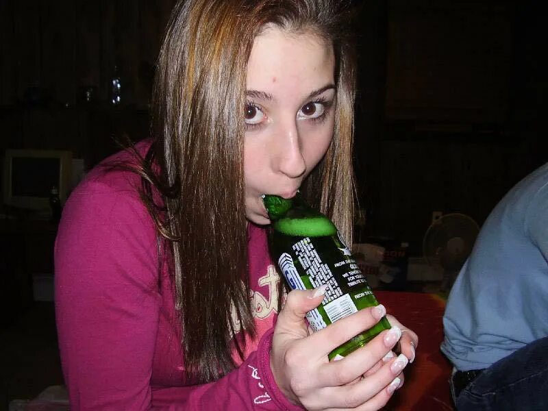 Фото девушки с бутылками пиво. Глотает бутылку.