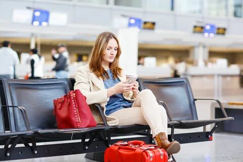 47230884 - young woman at international airport sitting waiting for cancell...