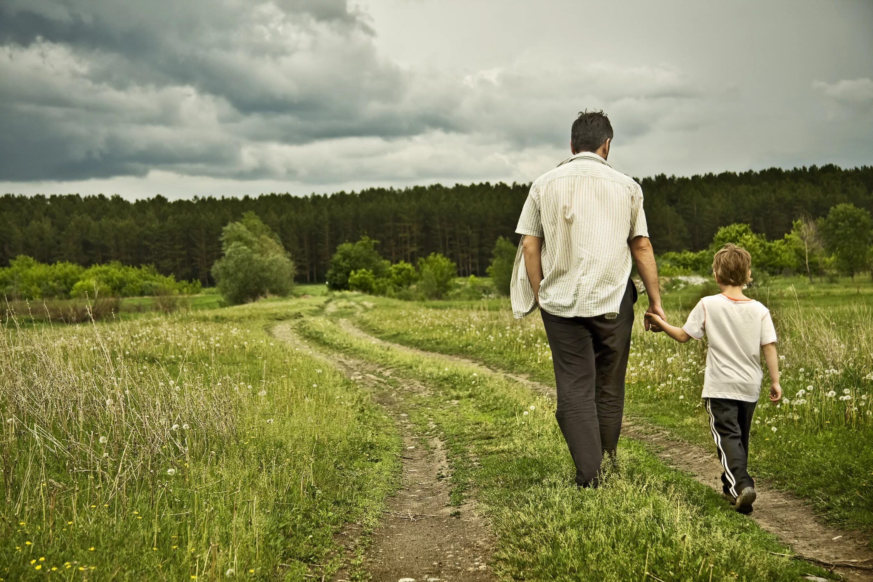 Человек на тропинке. Отец и сын идут по дороге. Отец с сыном на природе. Мальчик идет по дороге.