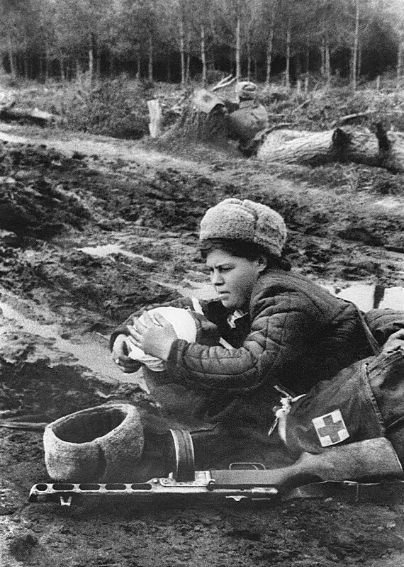 Выносит с поля боя раненого. Санинструкторы в годы вов 1941-1945. военные медики на поле боя вов. женщины на войне 1941-1945.