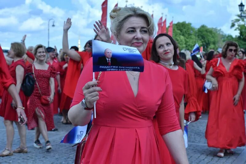 Девушка в платье на набережной в санкт-петербурге. Женщины в красном спб. Шествие в красных платьях красноярск. Шествие женщин в красном в сочи. Флешмоб в красном.