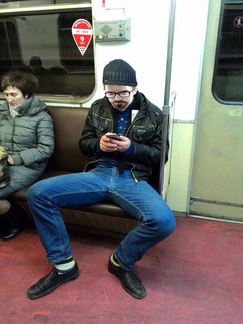 Мужчина сидит расставив ноги. Парень в метро. Парень сидит в метро. Парень сидит. Мужчины в Московском метро.