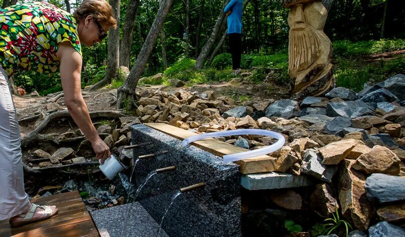 Где набрать питьевую. Человек у родника. Люди набирают воду из родника. Человек около родника. Родники у человека.