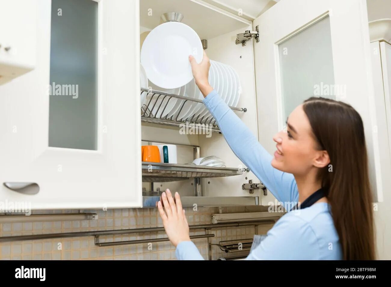 He put the plates. Beautiful maid sitting cleaning the floor with one hand holding a huge washing machine with the other hand.