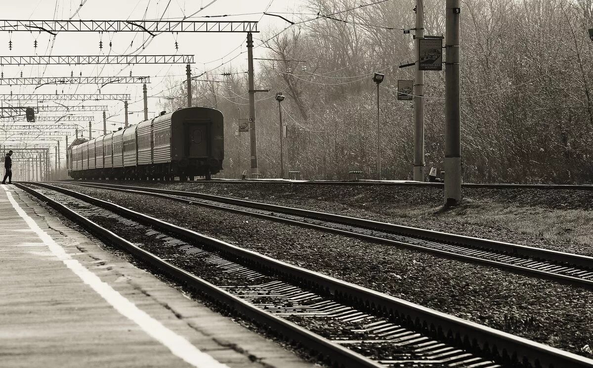 пустой перрон пустой вокзал. уходящий поезд. уезжать пустой. мужчина на вокзале. уходящий поезд.
