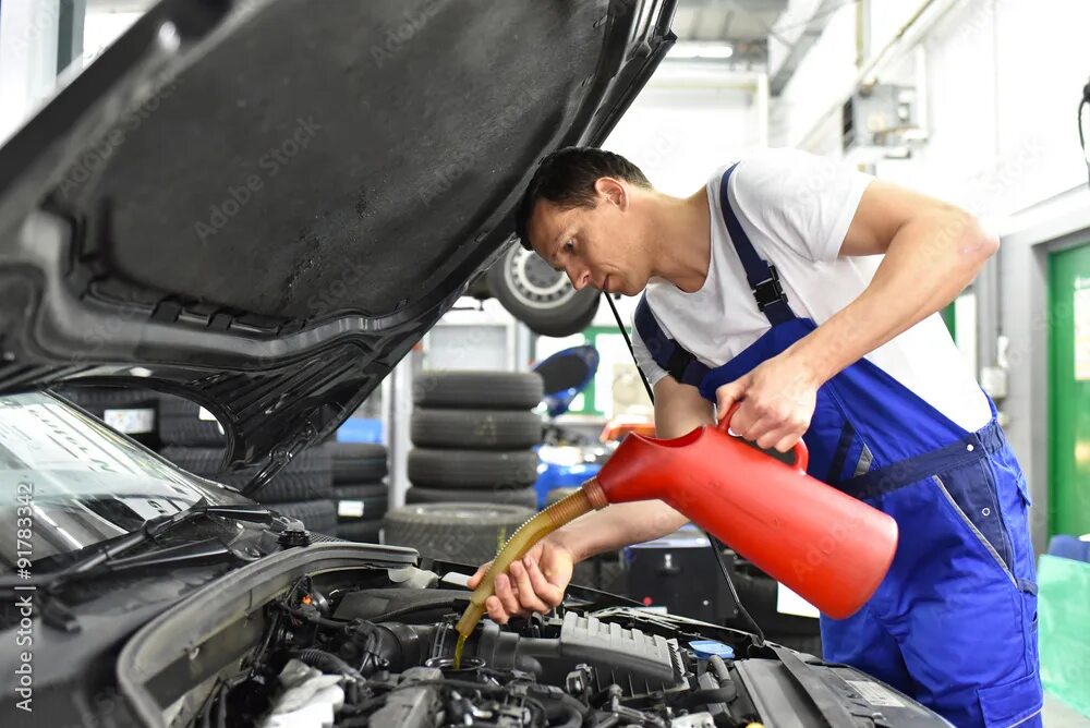Car mechanic как залить масло. Car oil service. mechanic change oil. механик заливает масло. engine oil change.