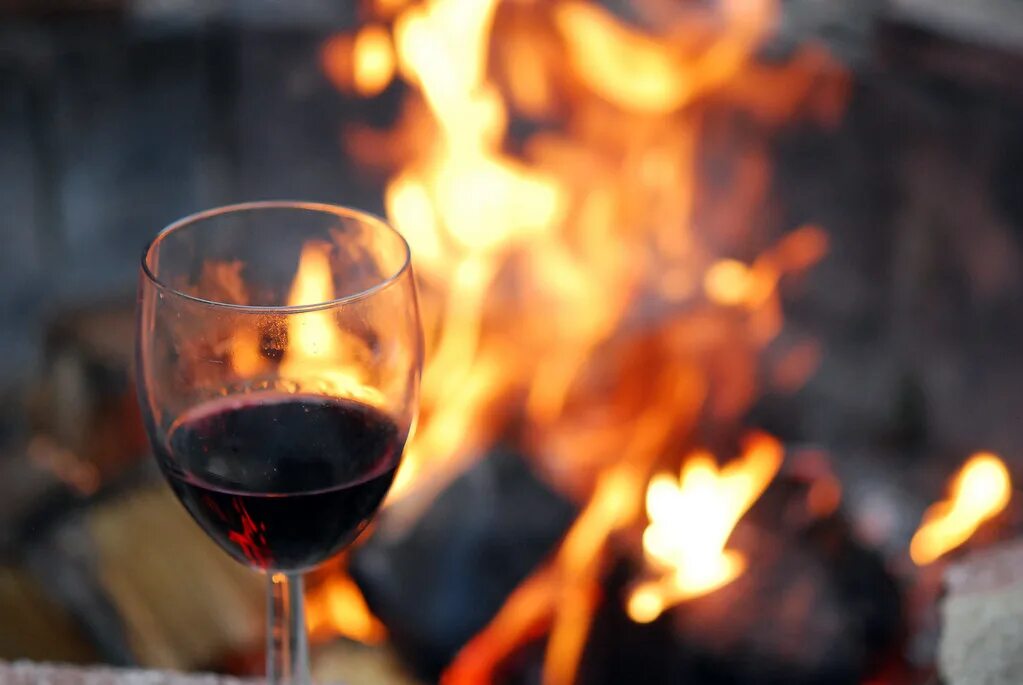 Бокал вина огонь. Камин вино. Бокал вина у костра. Шашлык в камине и вино. Огонь и вино.