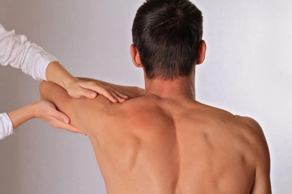 Руки на пояснице. Мануальная терапия. Рука человека со спины. Остеопатия.