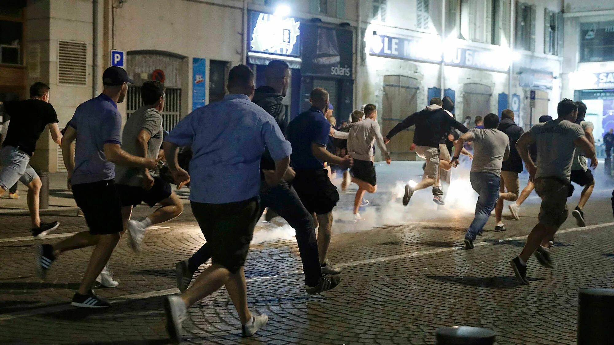 Дебош фанатов на улице города. Драка футбольных фанатов. толпа футбольных фанатов.