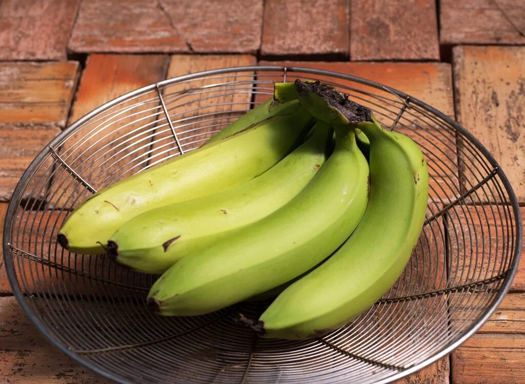 Зеленые бананы. Неспелый банан. Недозрелые бананы. Банан на столе.