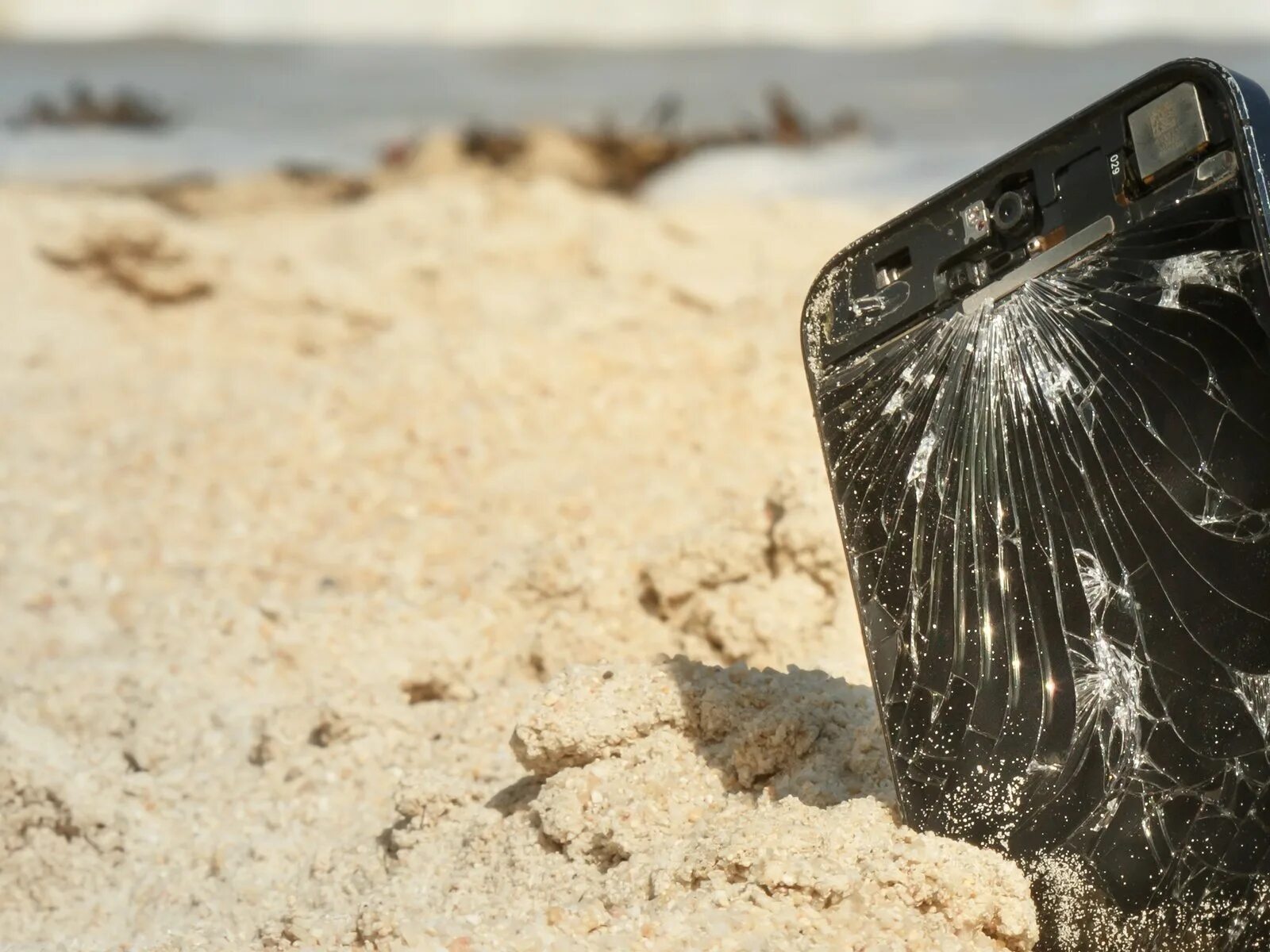 Разбивания телефонов. Разбитый смартфон. Смартфон в песке. Разбитый айфон. Сломанный смартфон.