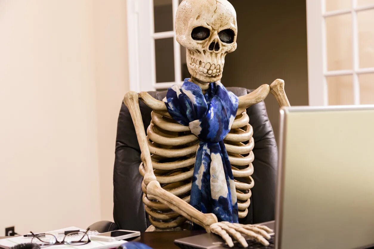 Скелет в офисе. Скелет за офисной работой.