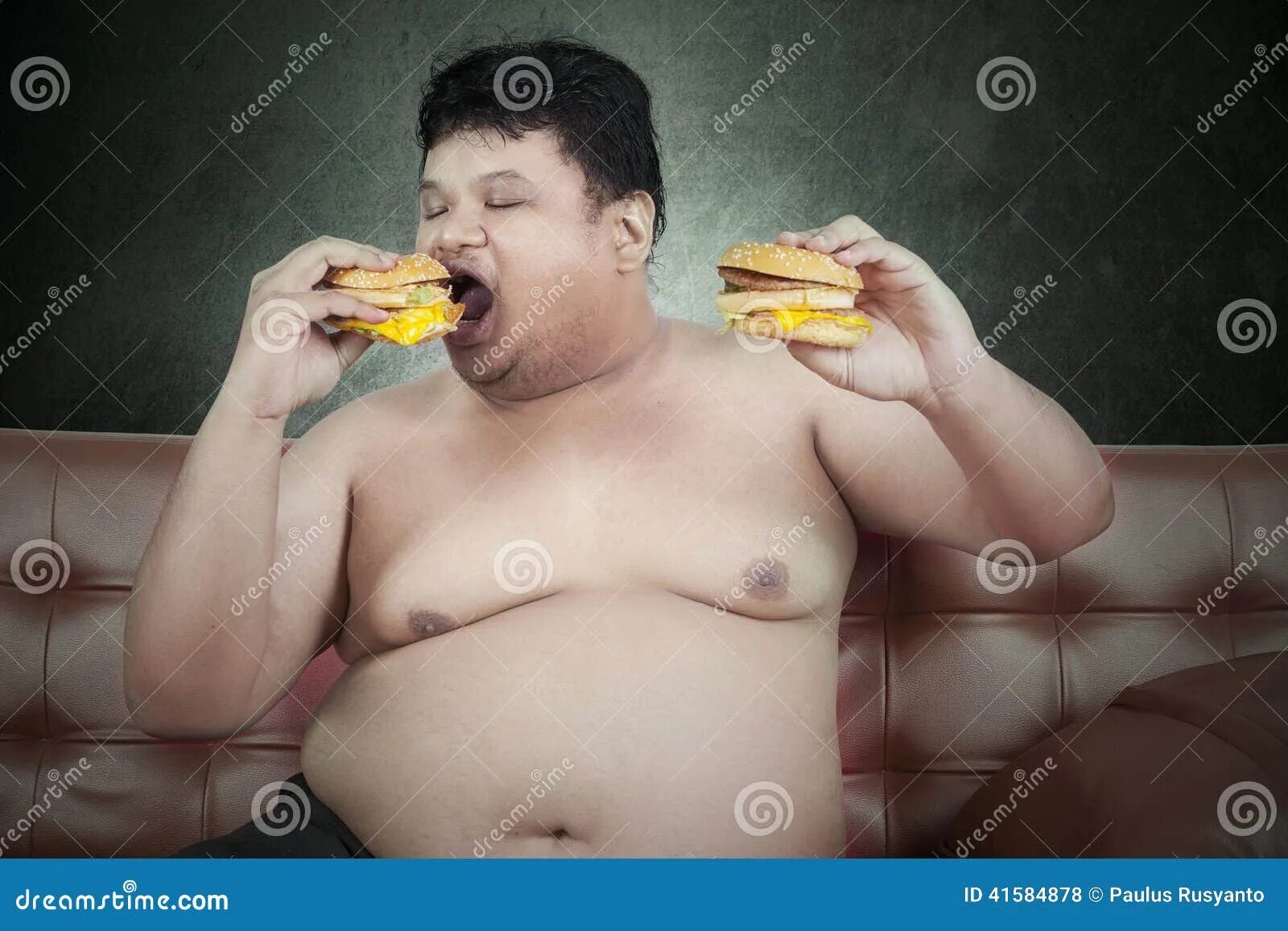 Толстяк с едой. Жирный ест гамбургер. Толстый человек ест бургер. Причины быть толстым