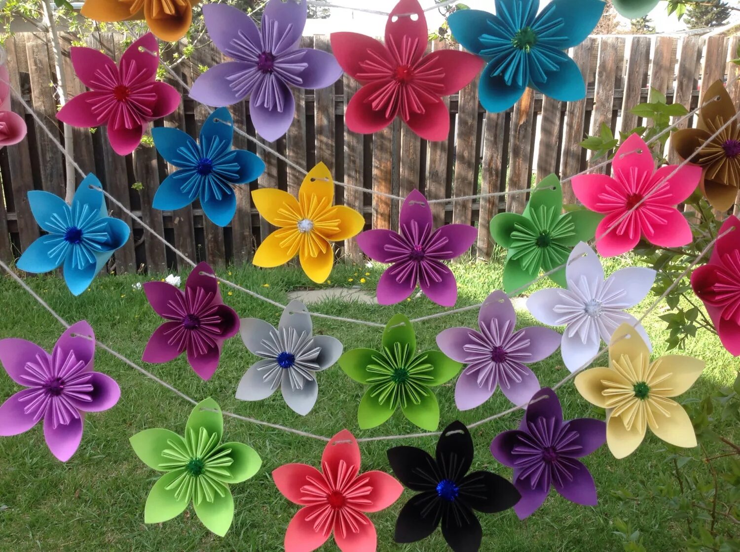 Красивые цветы из цветной бумаги. Украшение веранды в детском саду летом. Бумажные цветы для декора. Украшение потолка в детском саду к весне. Украшение группы на выпускной в саду.