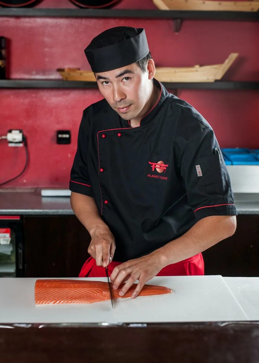 Cunning Chef Wwinking To the Camera while Holding a Plate with Sushi Stock Image