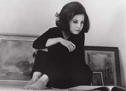 a black and white photo of a woman sitting at a desk.