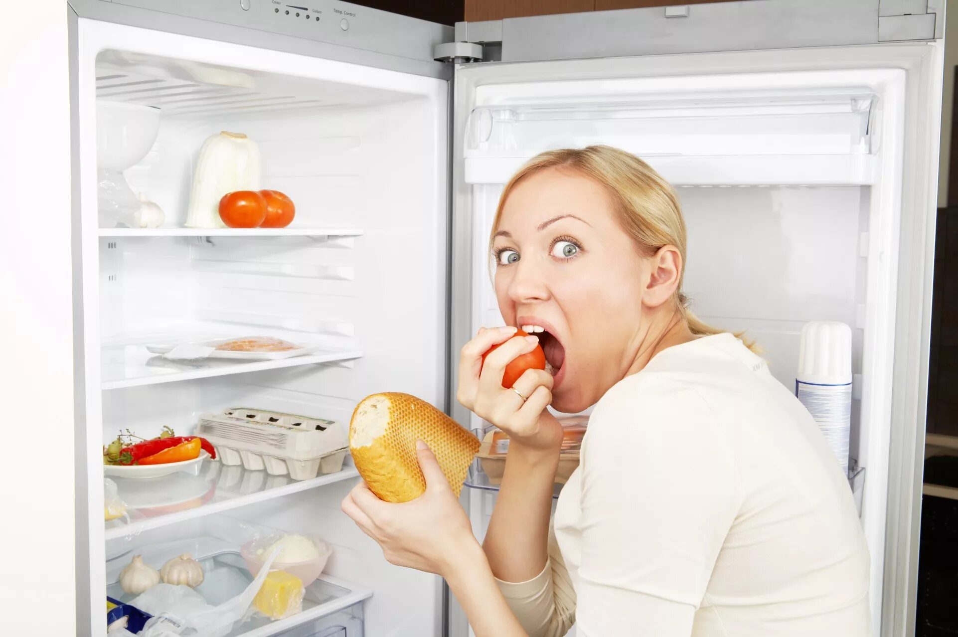 Компульсивное переедание. Женщина у холодильника. Холодильник с едой. Пищевые привычки.