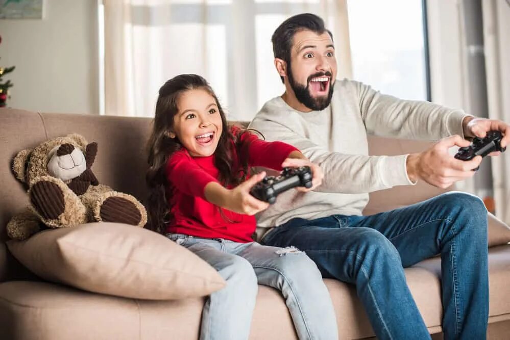 Dad likes playing. Играет с отцом в Видеоигры. Семья играет в Видеоигры Сток. Папа и Дочки с джойстиками. Отец играет с дочкой в приставку.